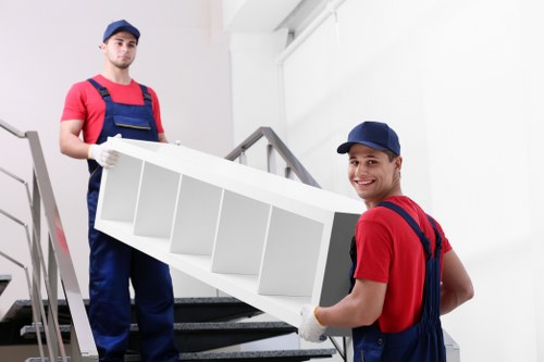 Movers carrying furniture from a flat in southeast London